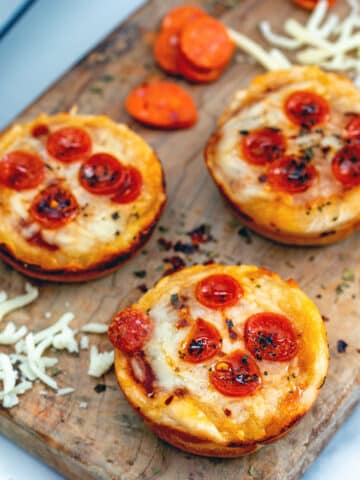Closeup view of mini pepperoni pizza cupcakes on wooden board.