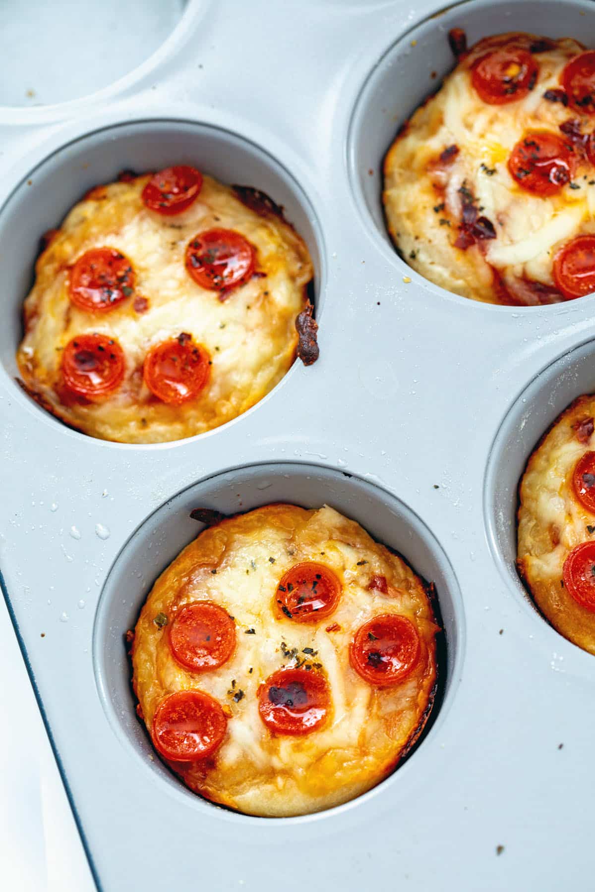 Closeup view of pepperoni pizza cupcakes in tin.