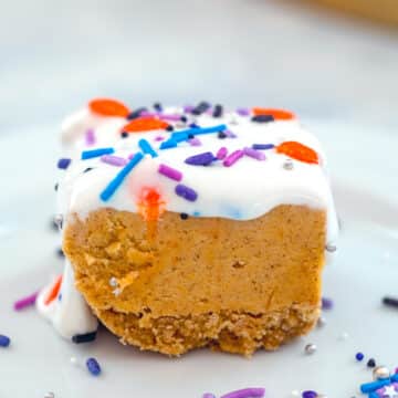 Closeup view of a pumpkin cookie dough bar with marshmallow topping and sprinkles.