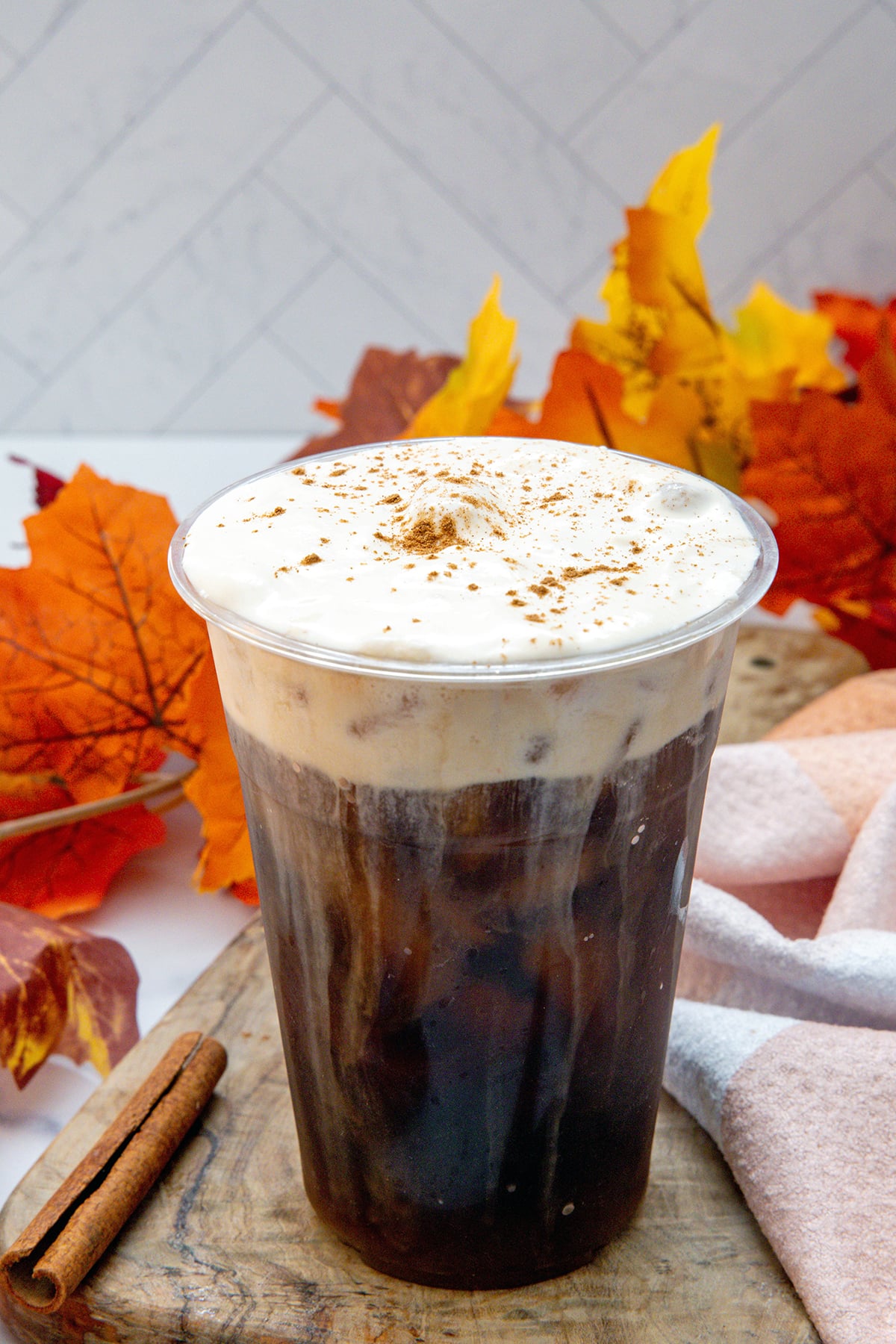 Head-on view of a cup of iced coffee topped with pumpkin cold foam.