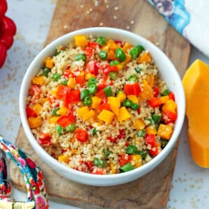 Overhead closeup view of a bowl of quinoa for dogs with butternut squash, red pepper, and green beans.