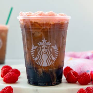 Closeup head-on view of a Raspberry Cream Cold Brew in a Starbucks cup.