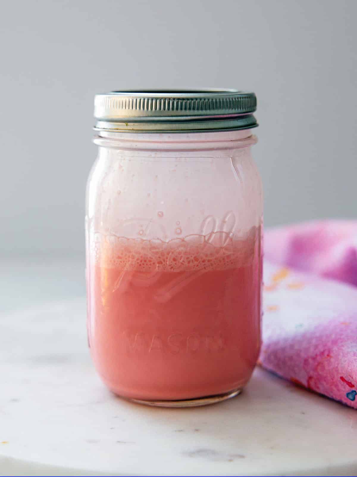 Head-on view of a mason jar of raspberry sweet cream.