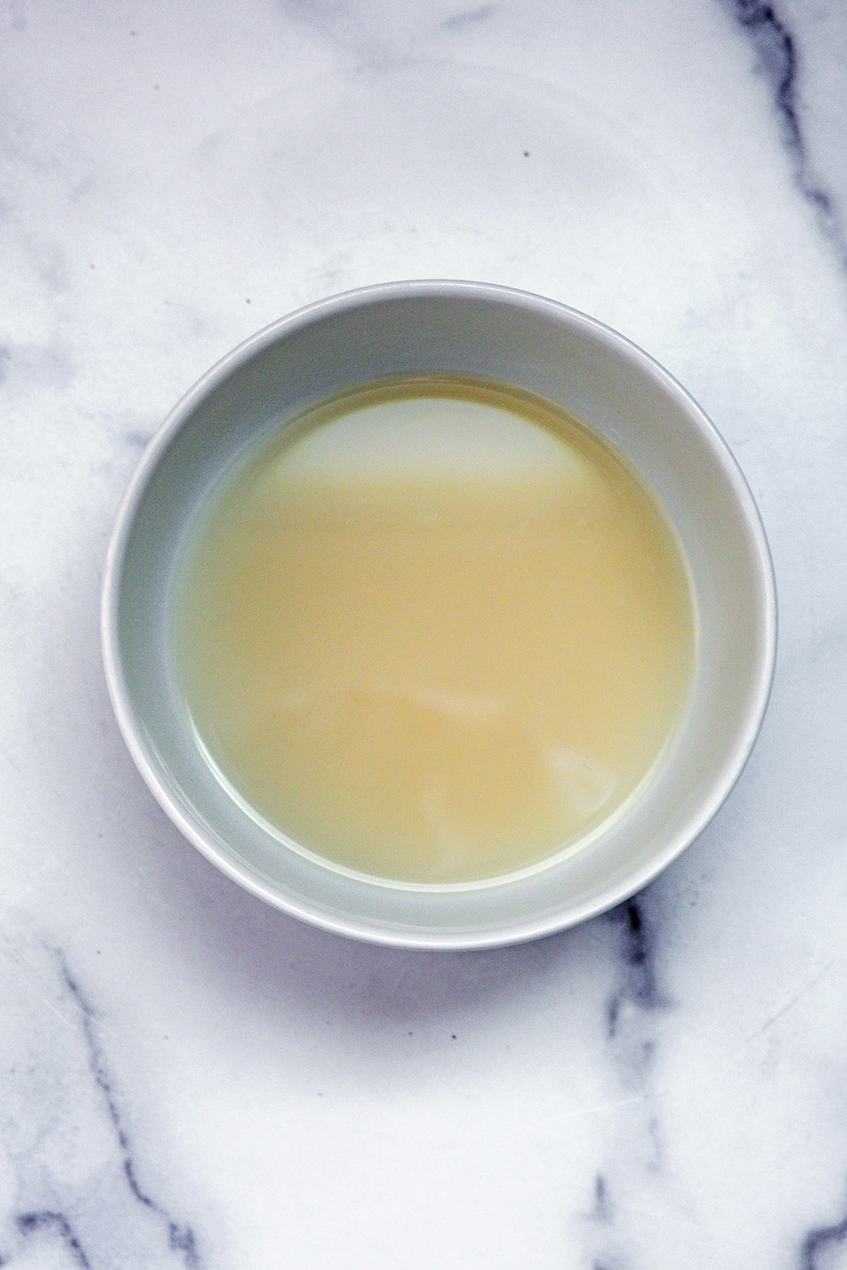 Cloudy water in bowl after rice is strained out.