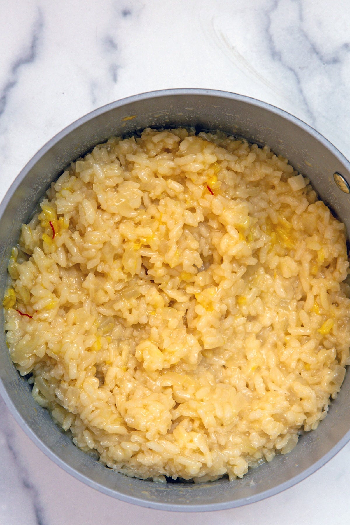 Risotto with saffron in saucepan.