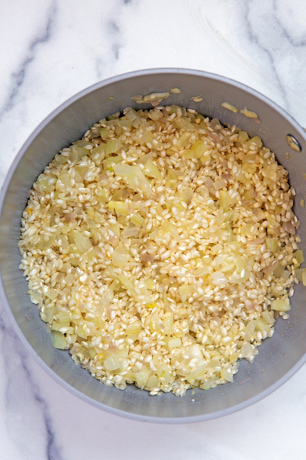 Arborio rice added to saucepan with onion and garlic.