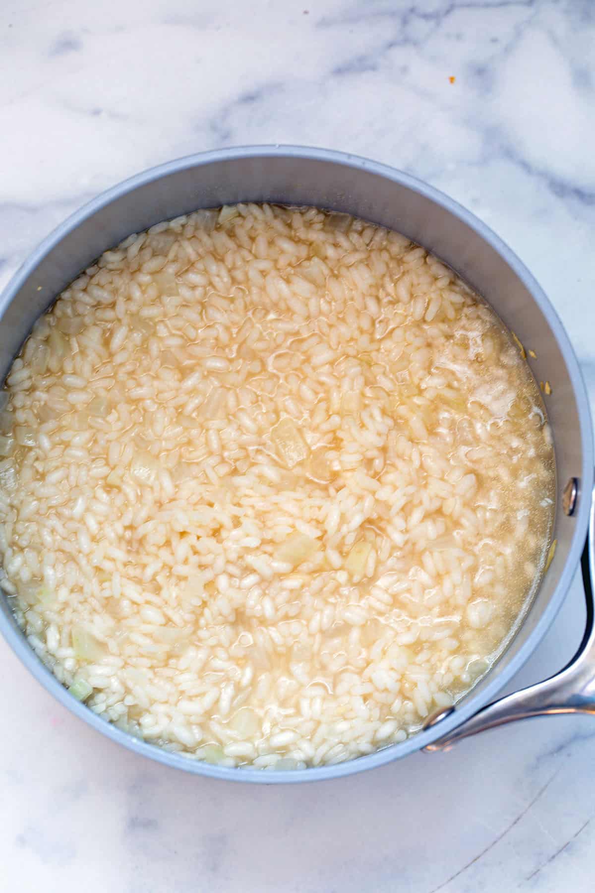 Risotto in saucepan with broth.