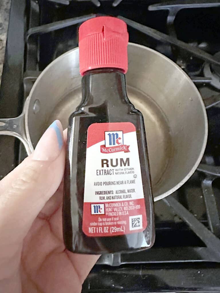 Rum extract bottle over saucepan.