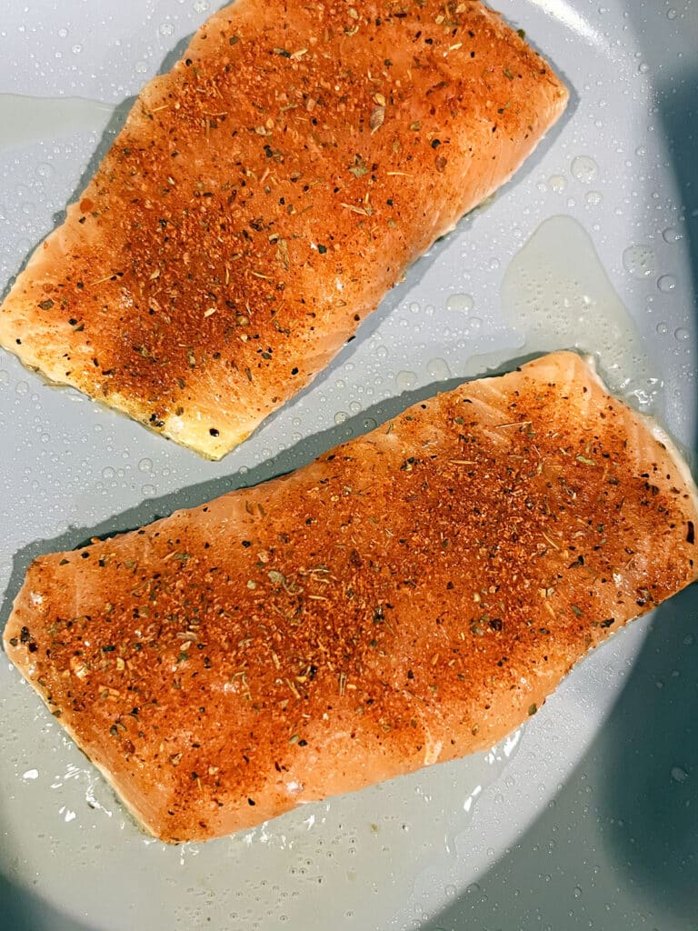 Salmon cooking in skillet.