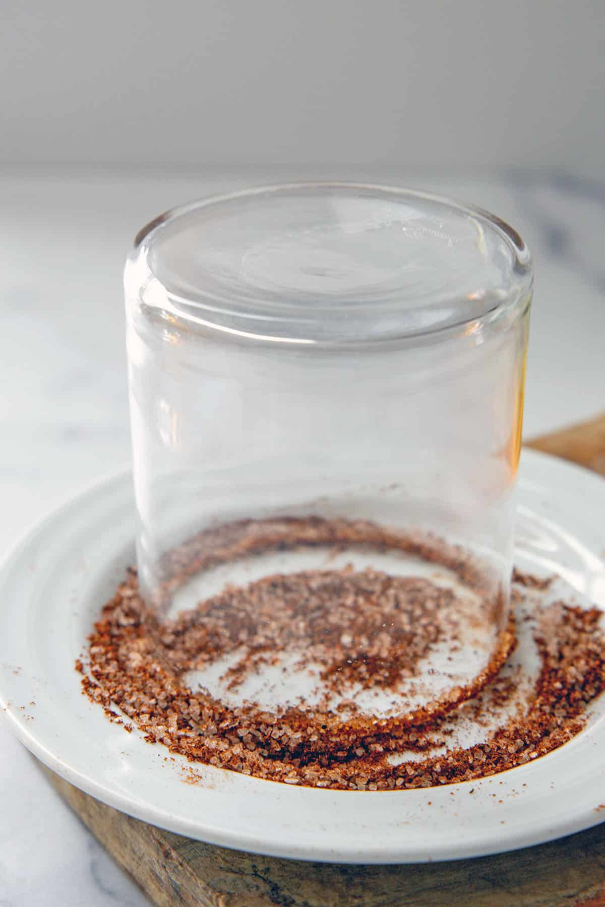 Glass upside down on a plate with a salt and chili powder mixture.