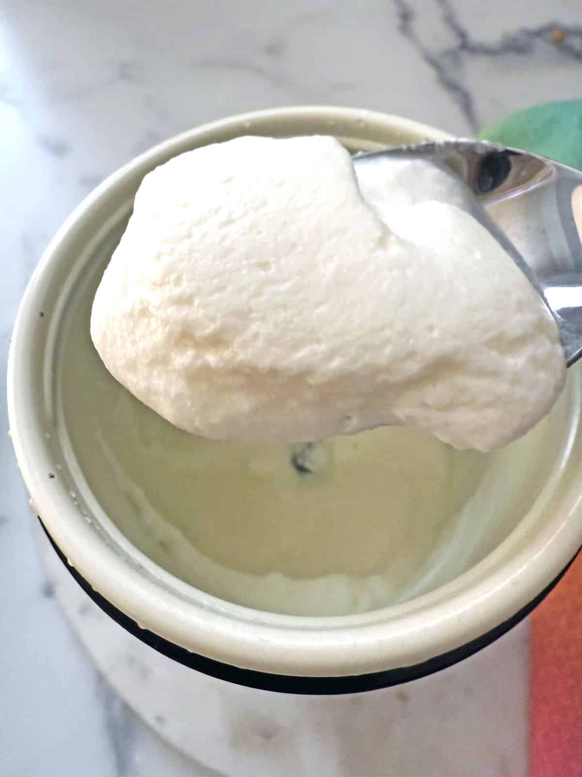 Salted caramel cold foam on a spoon.