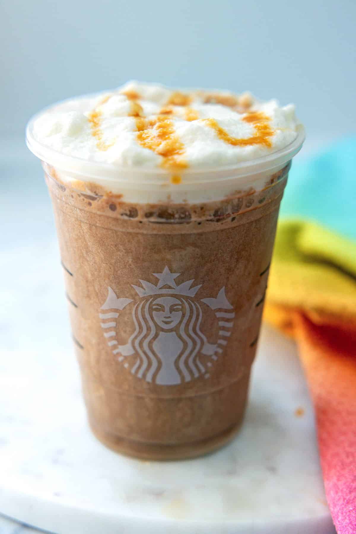 Overhead view of Salted Caramel Mocha Frappuccino with salted carmel drizzle over cold foam.