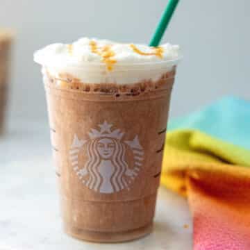 Closeup view of a Salted Caramel Mocha Strato Frappuccino with green straw.