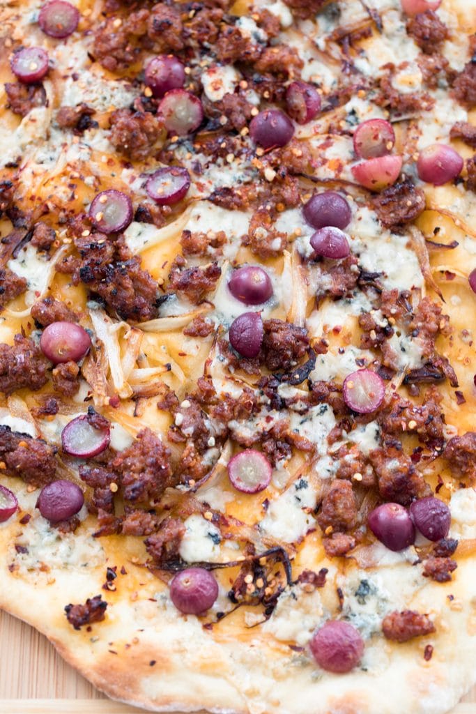 A close-up of the sausage, grape, and gorgonzola flatbread just out of the oven