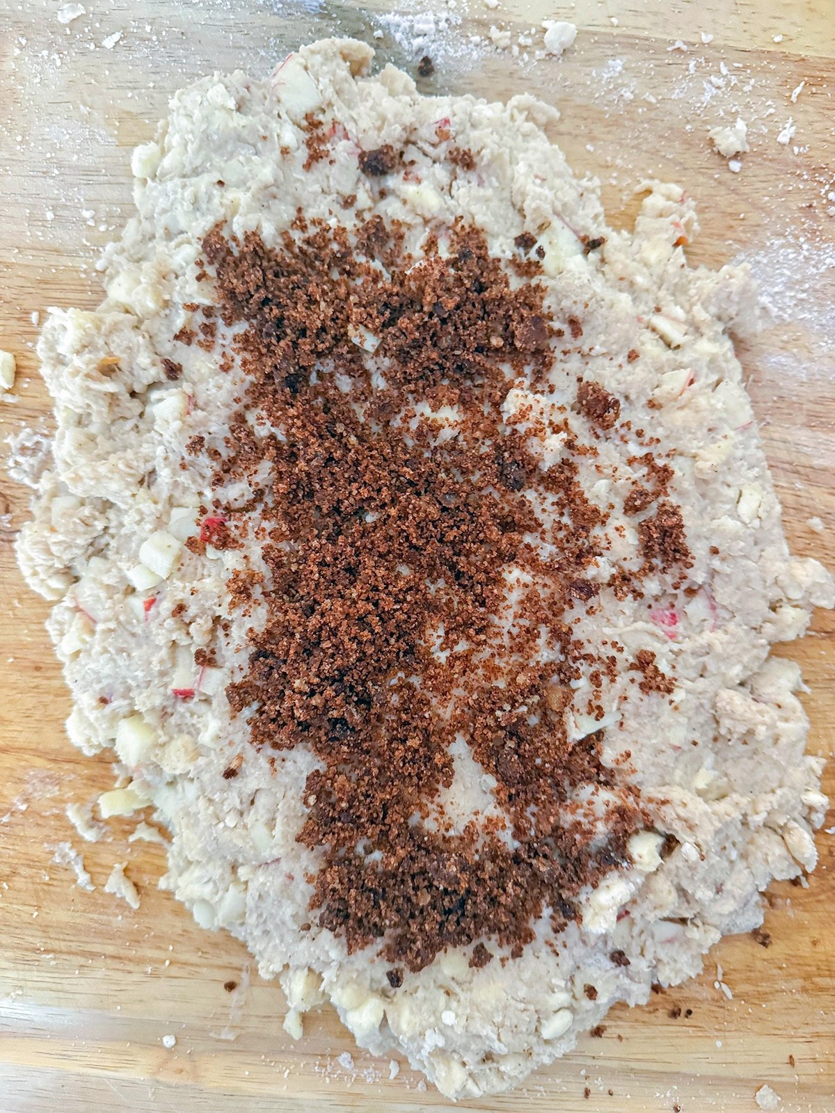 Scone dough rolled out with cinnamon sugar mixture sprinkled over.