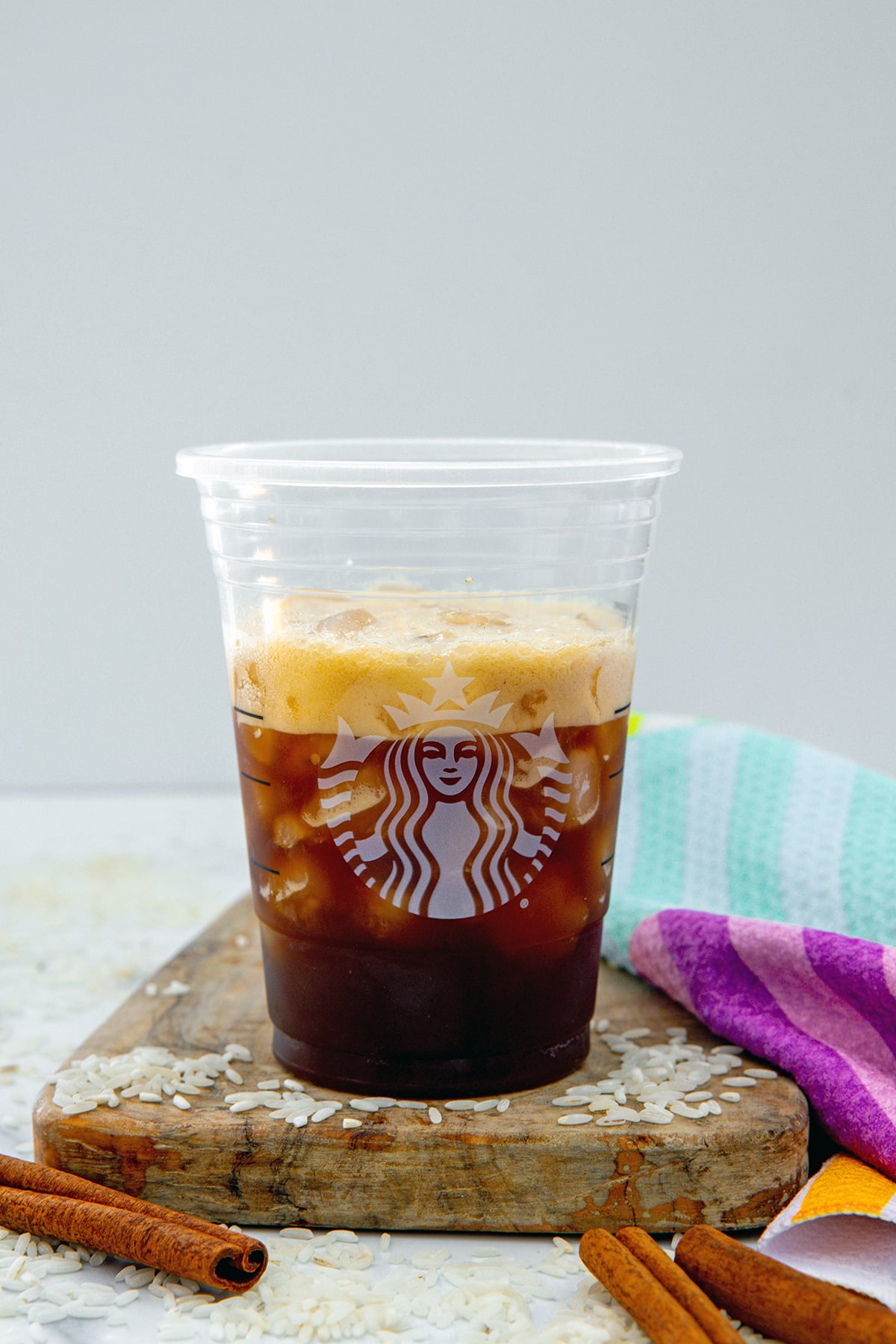 Frothy espresso and ice poured into Starbucks cup.