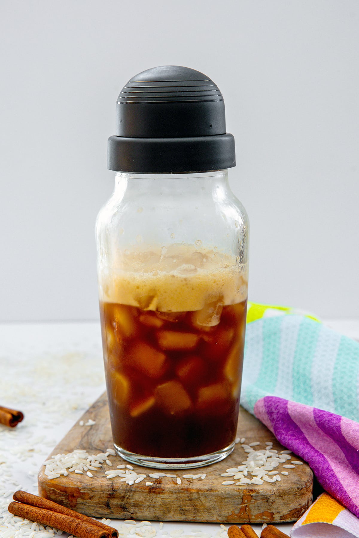 Head-on view of a clear shakes with espresso and ice shaken up.