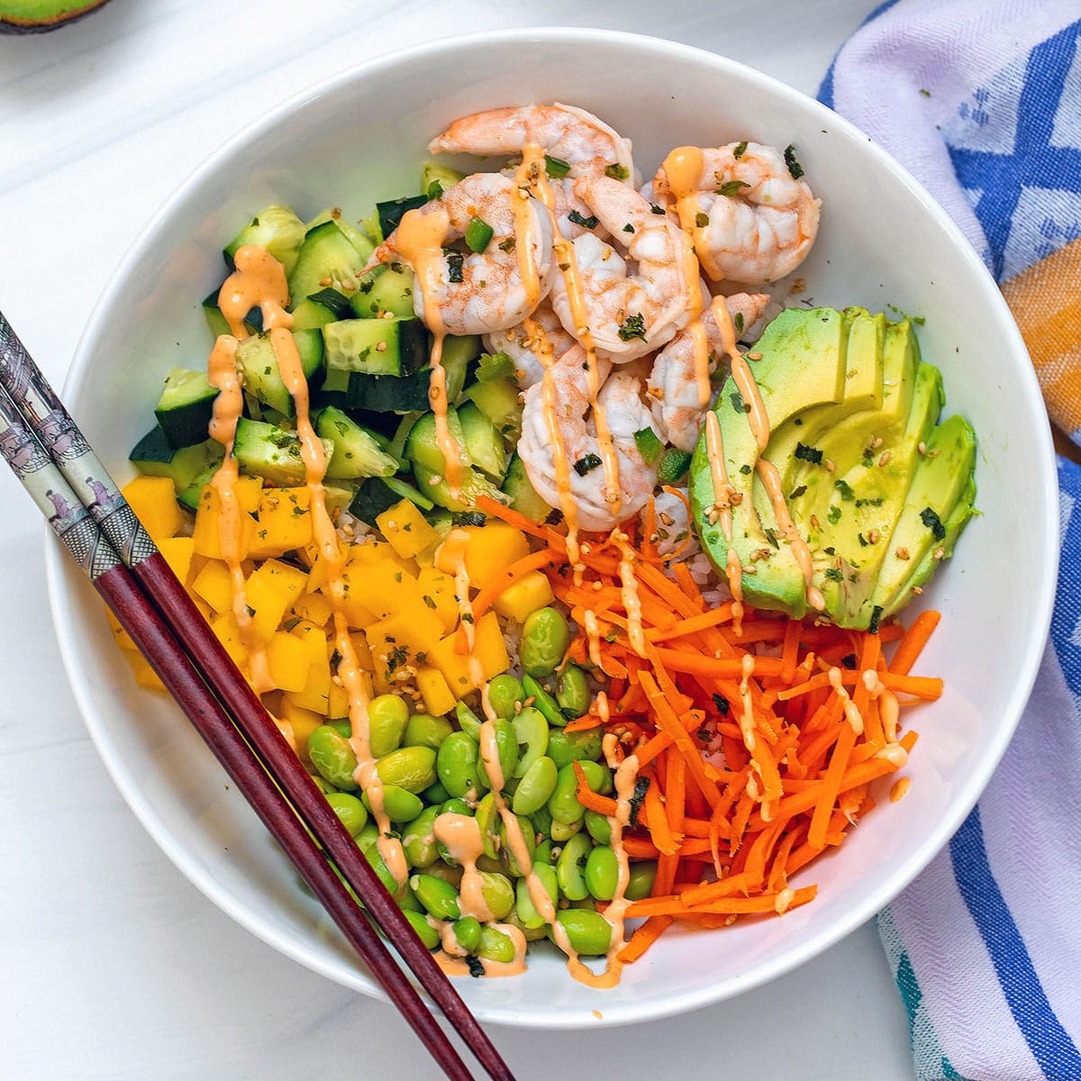 Overhead view of shrimp poke bowls with lots of bright colors.