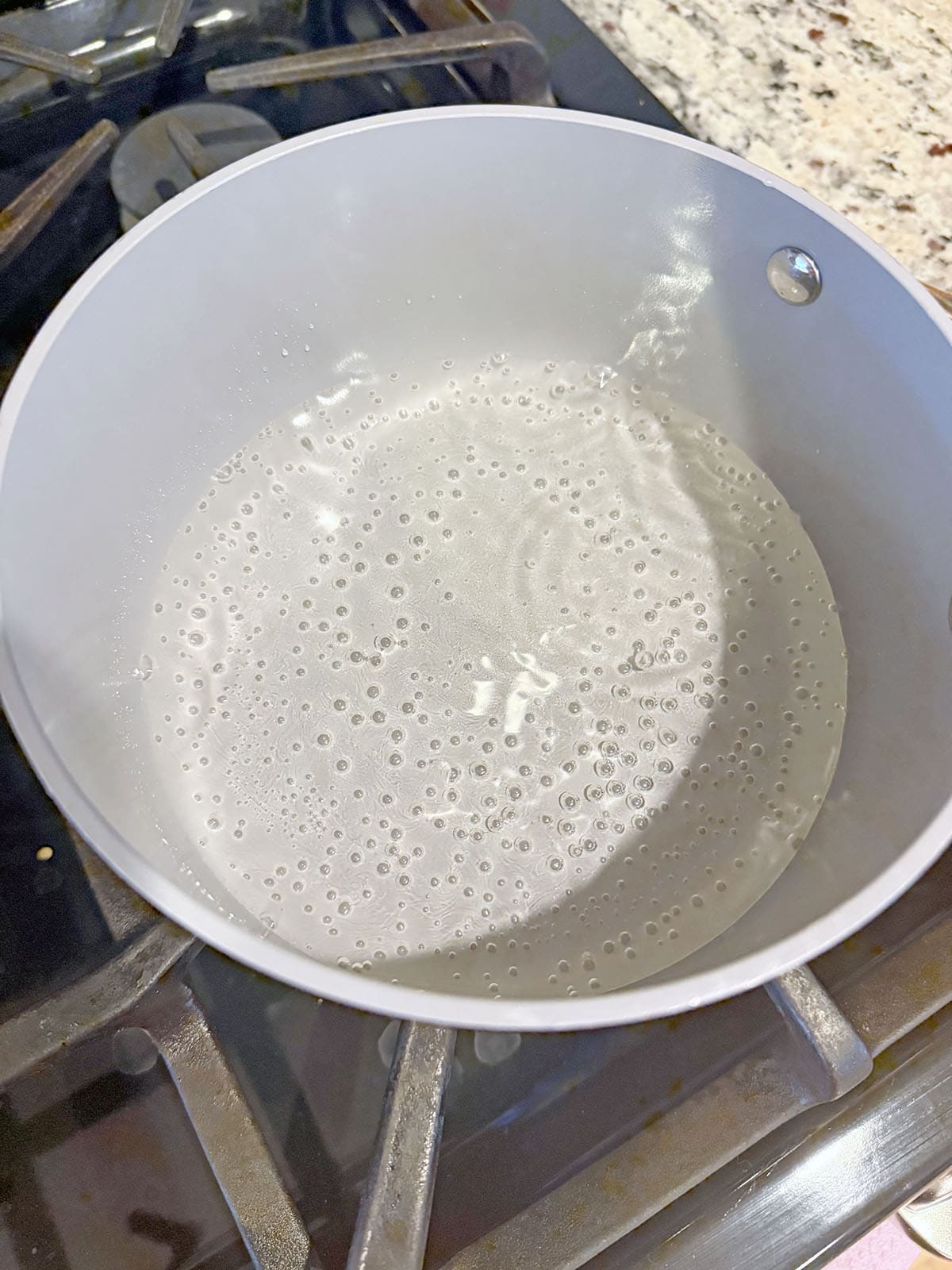 Simple syrup simmering in saucepan.