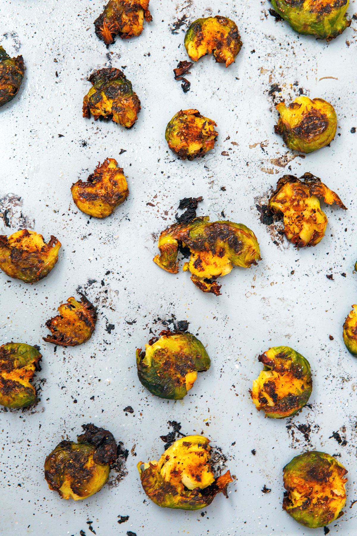 Smashed brussels sprouts just out of the oven on baking sheet.