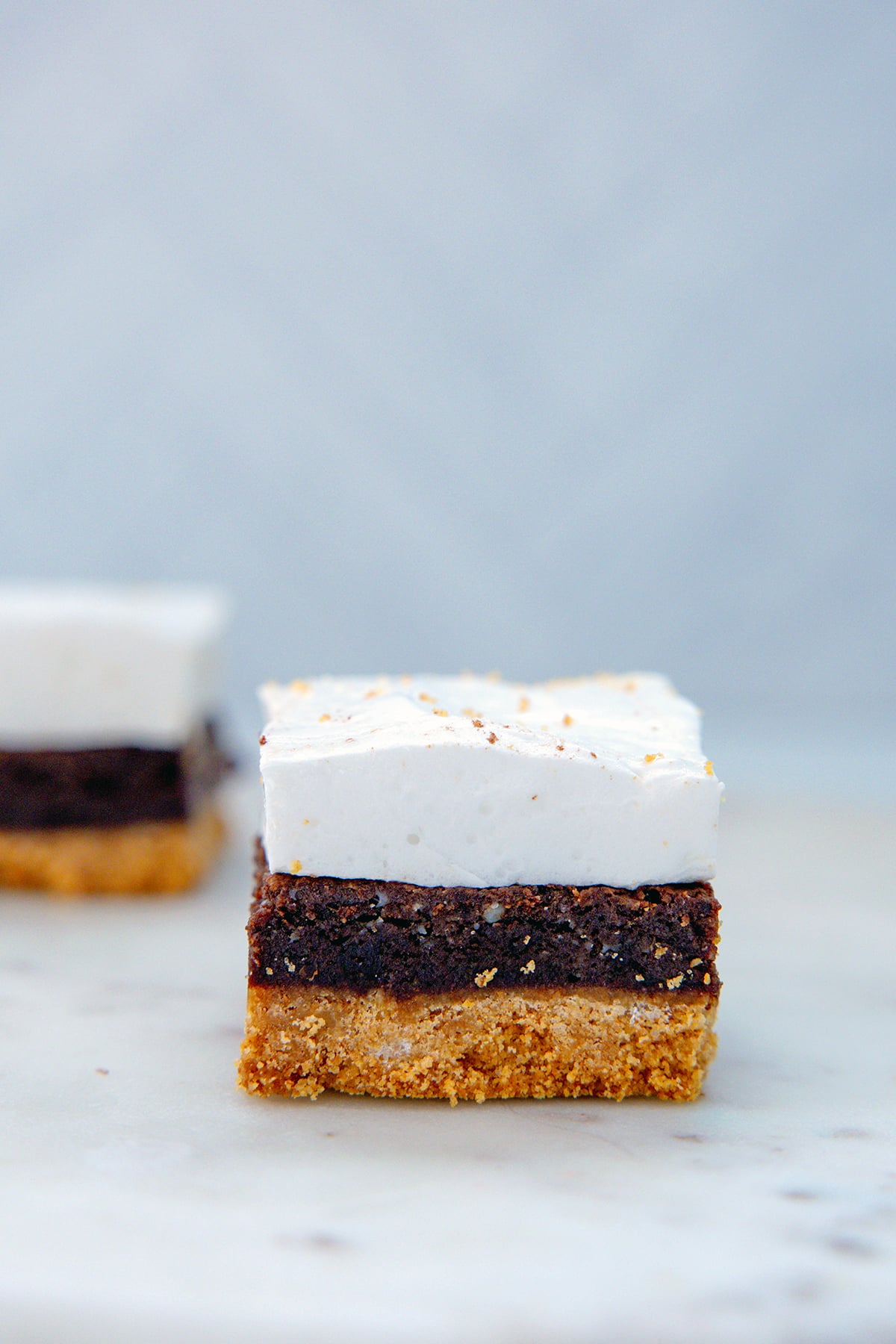 Head-on view of the uncoated bar with graham cracker crust, brownie middle, and marshmallow topping.