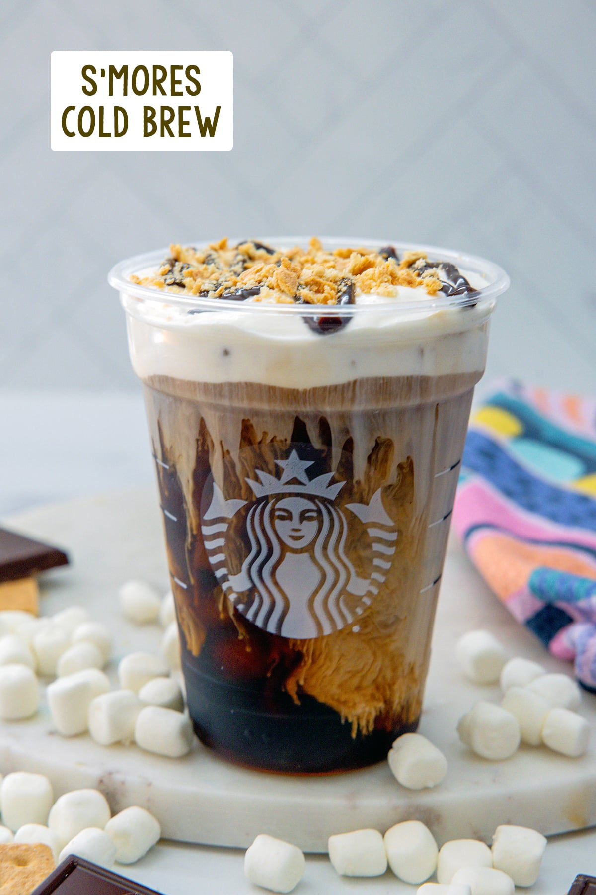 Head-on view of a s'mores cold brew topped with chocolate drizzle and graham cracker crumbs with recipe title at top.