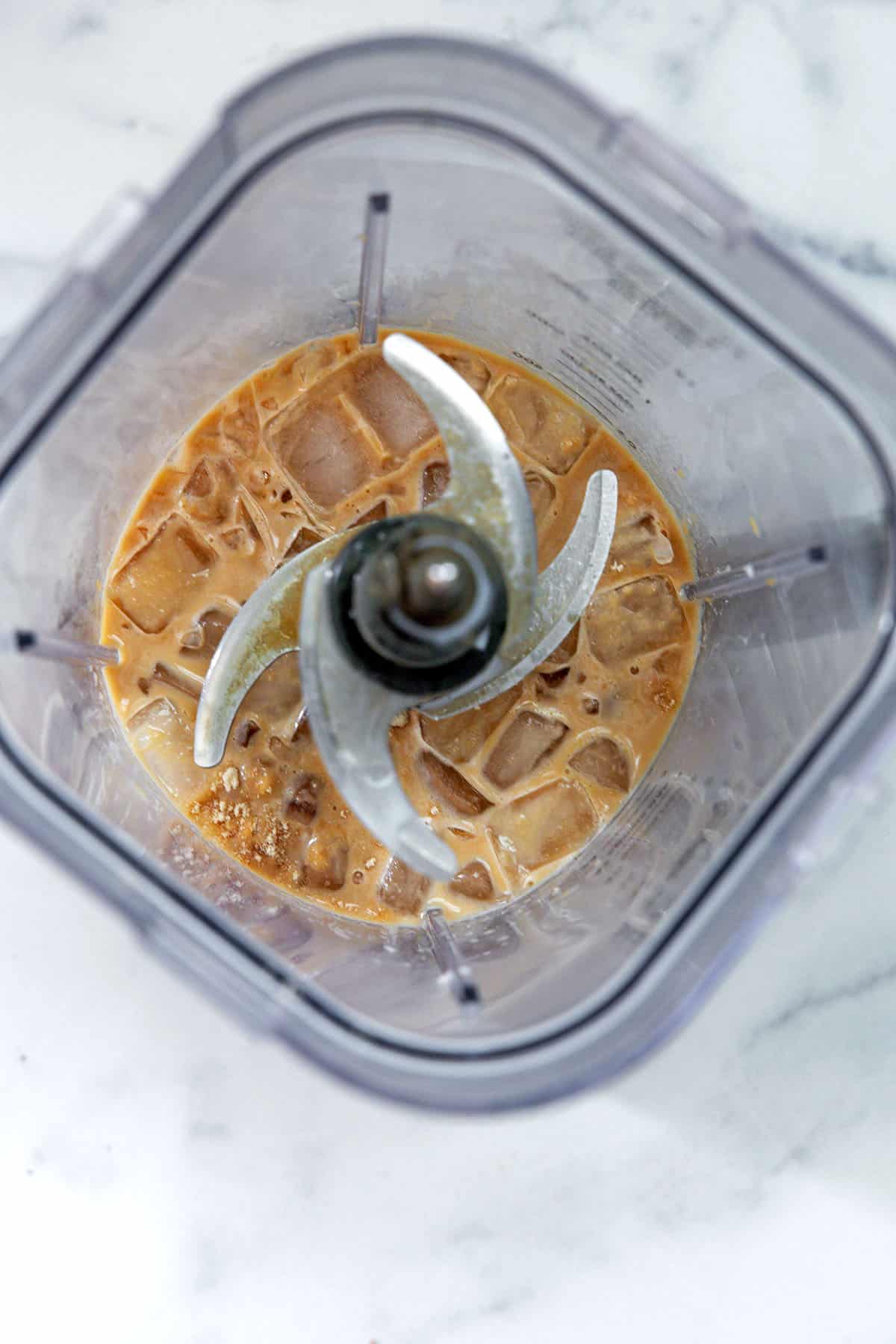 Overhead view of s'mores Frappuccino ingredients with ice in blender.
