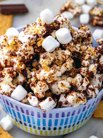 Closeup view of a bowl of s'mores popcorn with mini marshmallows on top.