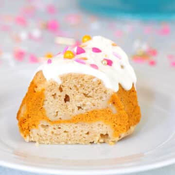 Closeup view of a slice of cake with pumpkin swirl and white sour cream frosting.