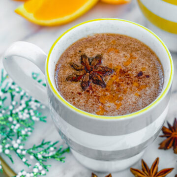Closeup overhead view of a spiced hot btutered rum with star anise garnish.