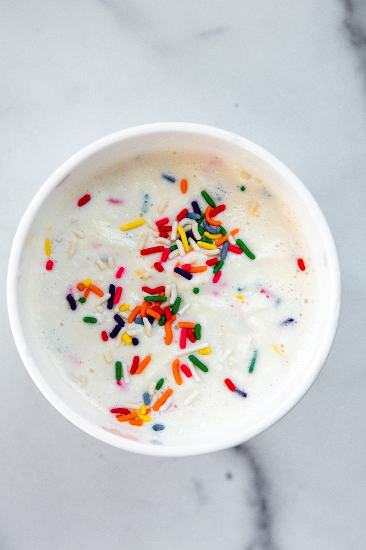 Overhead view of sprinkles ice cream chilling in ice cream container.