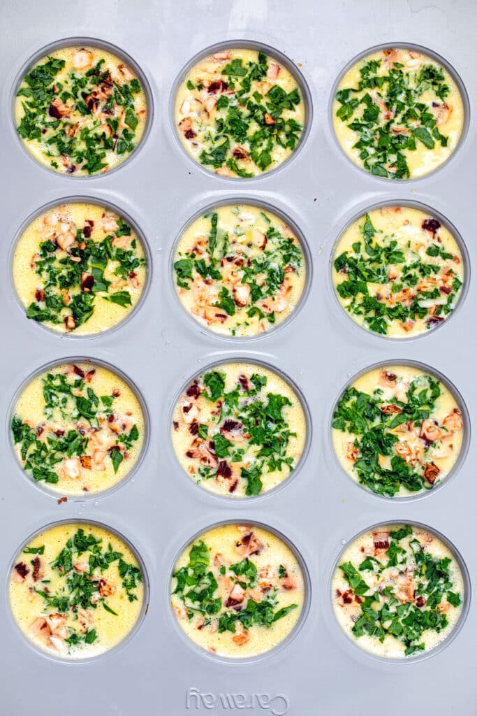 Egg and cottage cheese mixture in muffin tins with kale and mushrooms.