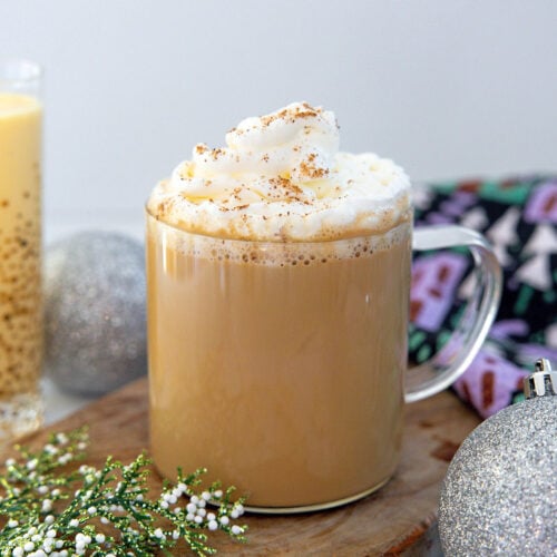 Closeup head-on view of an eggnog latte topped with whipped cream.