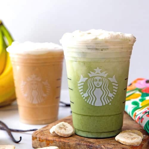 Head-on view of a protein matcha banana latte and an iced protein vanilla latte in Starbucks cups.