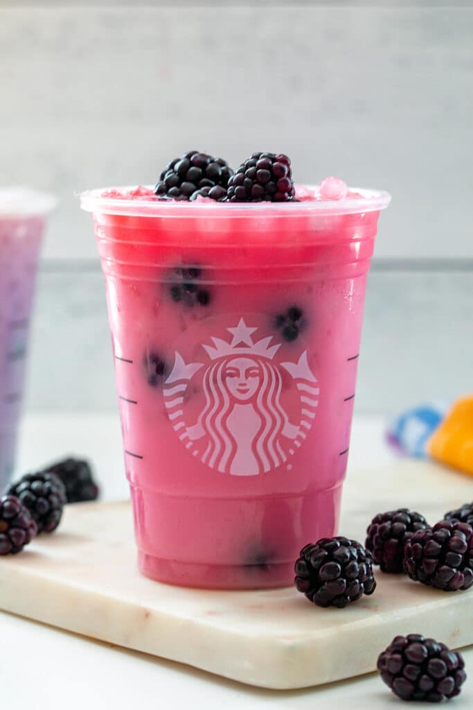 Starbucks "Purple Drink" with coconut that looks pink in a Starbucks cup.