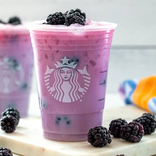 Purple Drink in Starbucks cup with blackberries all around.