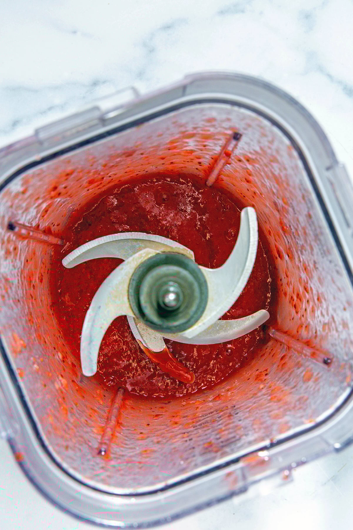 Overhead view of strawberry puree in blender.