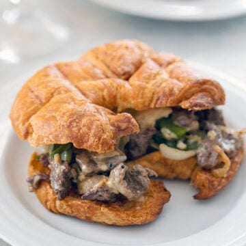Closeup of a steak and cheese croissant sandwich.