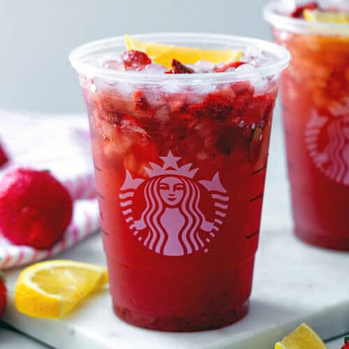 Closeup view of a Strawberry Acai Lemonade drink in a Starbucks cup.