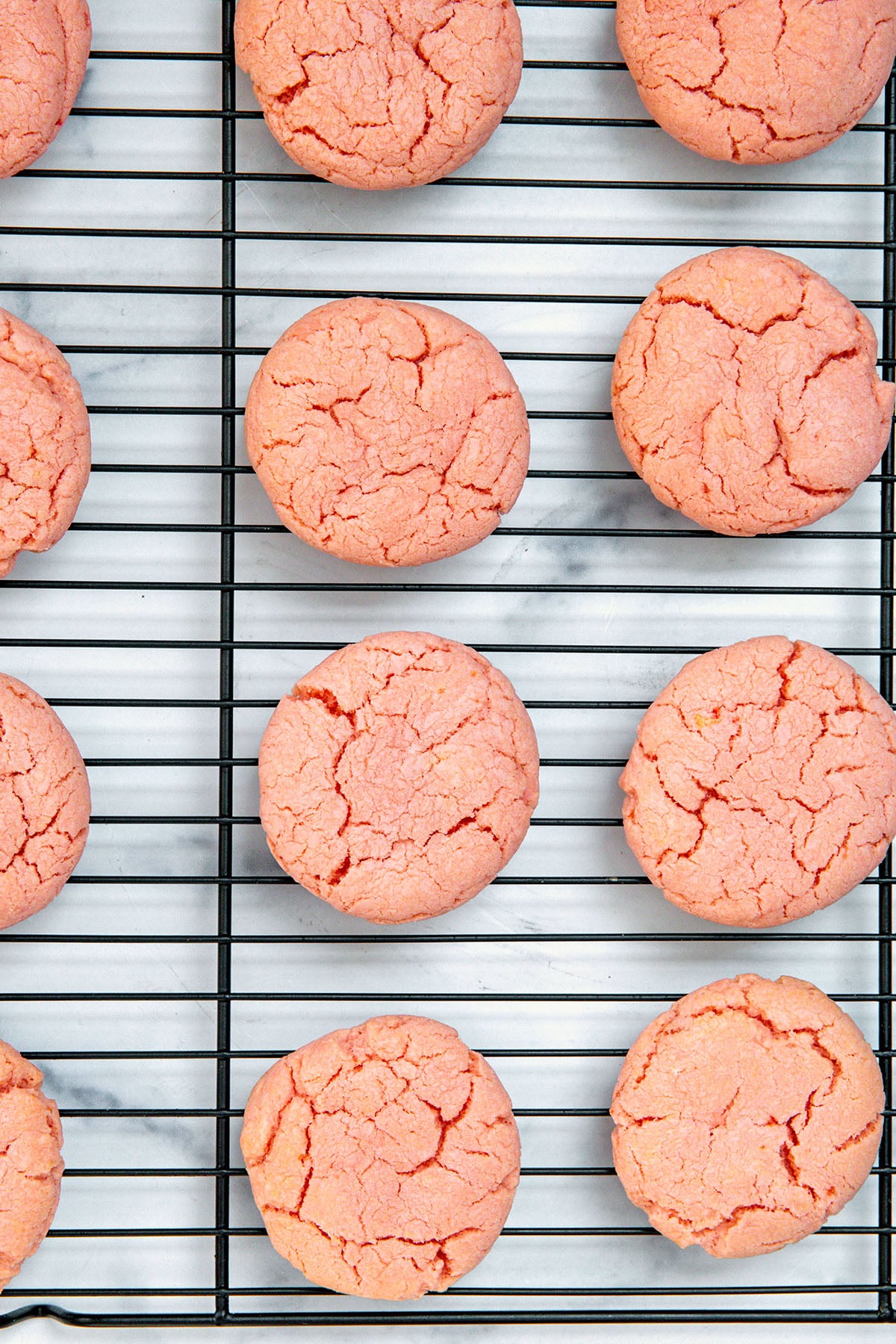 Strawberry cake mix cookies cooling on baking rack.
