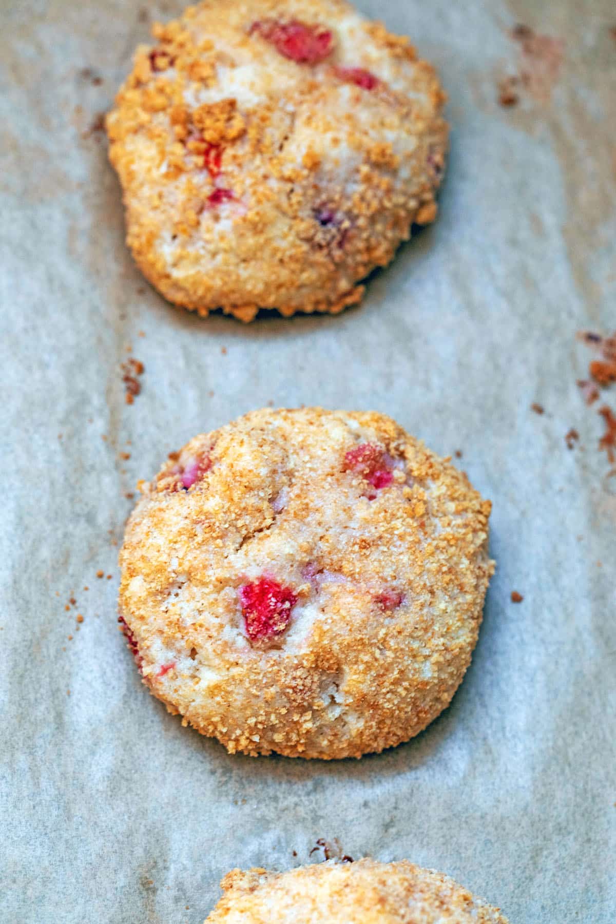 Strawberry cheesecake cookies baked on parchment paper-lined baking sheet.