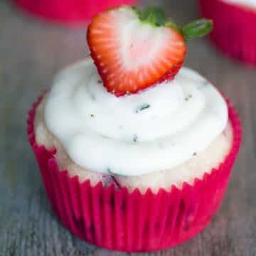 Closeup view of a strawberry cupcakes with goat cheese mint buttercream frosting.