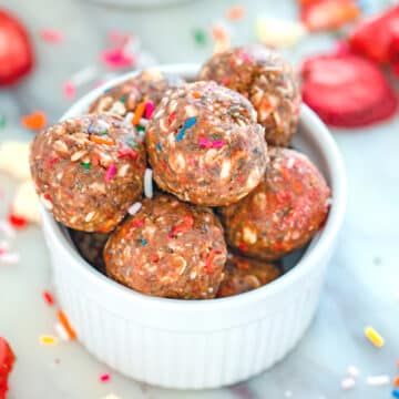 Closeup view of strawberry funfetti energy bites in a small white bowl.