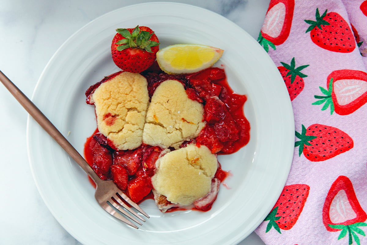 Strawberry lemonade cookie cobbler on white plate with fork.