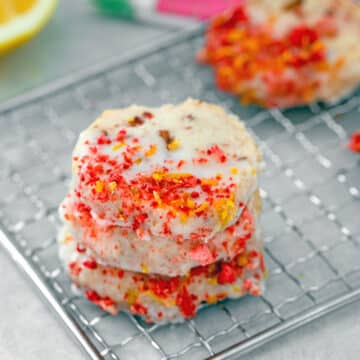 Closeup view of stack of strawberry lemonade shortbread cookies with crushed freeze-dried strawberries.