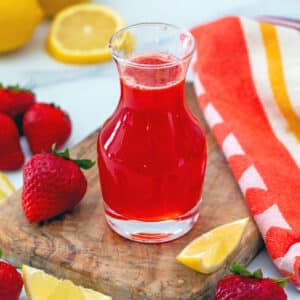 Strawberry lemonade syrup in glass bottle.