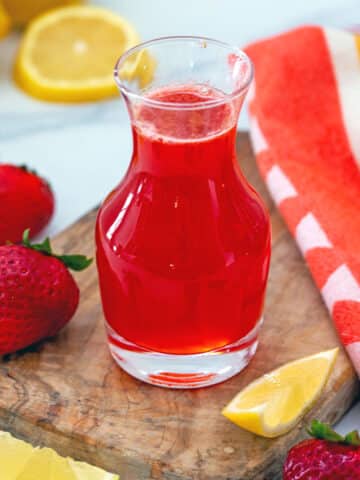 Strawberry lemonade syrup in glass bottle.