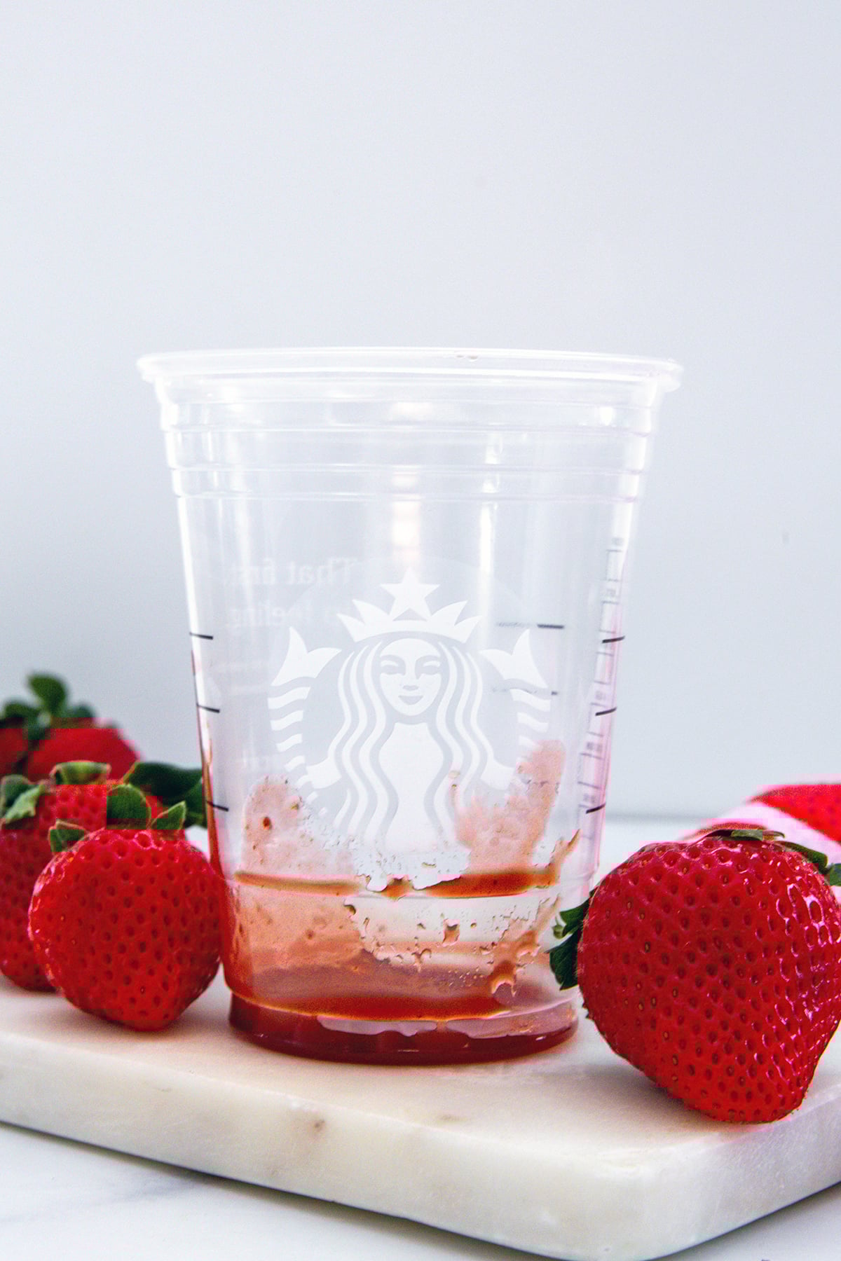 Starbucks cup with strawberry puree on the bottom of it.