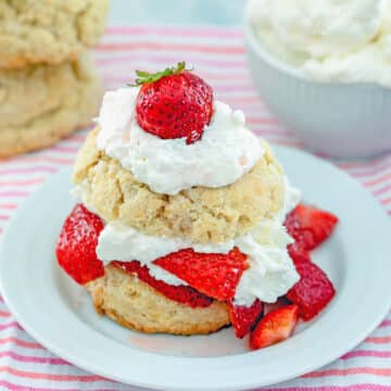 Head-on view of a strawberry shortcake made with homemade biscuits and whipped cream and fresh strawberries.