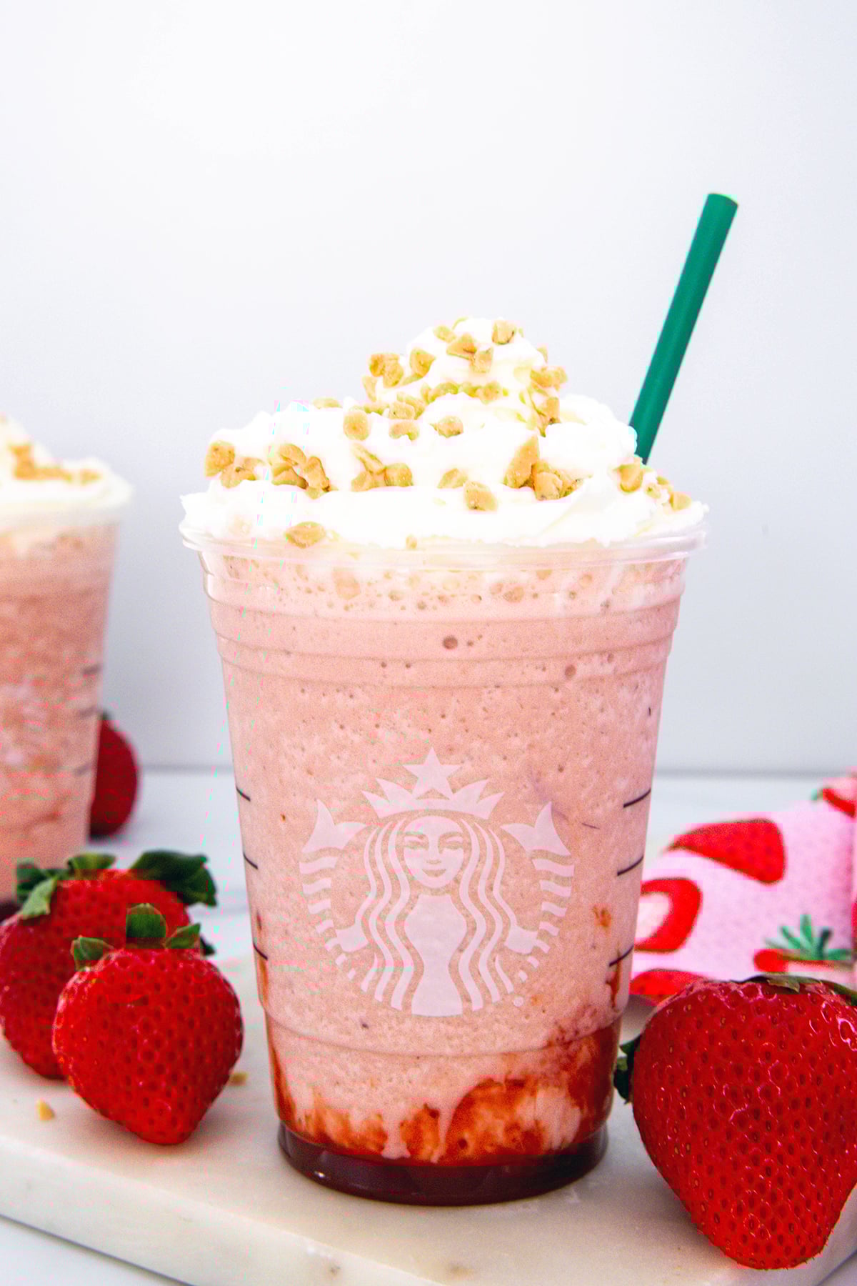 Head-on view of a Strawberry Shortcake Frappuccino with whipped cream and toffee bits.